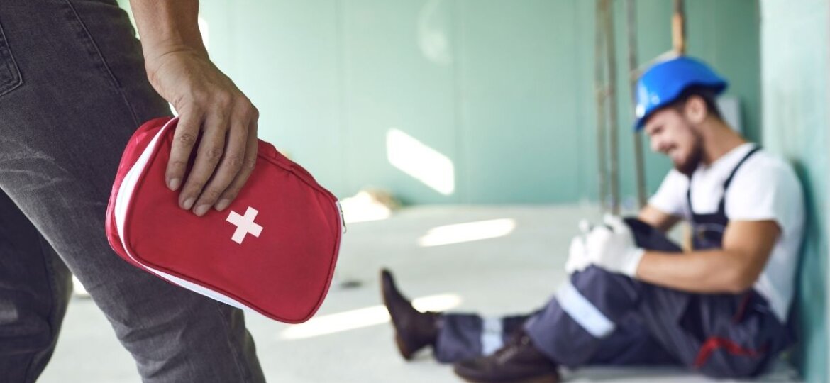 work-related injuries of a worker with his colleague bringing first aid kit