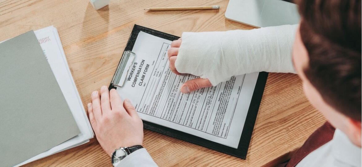 Injured employee reading the workers compensation form on the wooden table