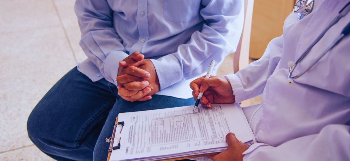 The man is undergoing a workers' comp independent medical exam.